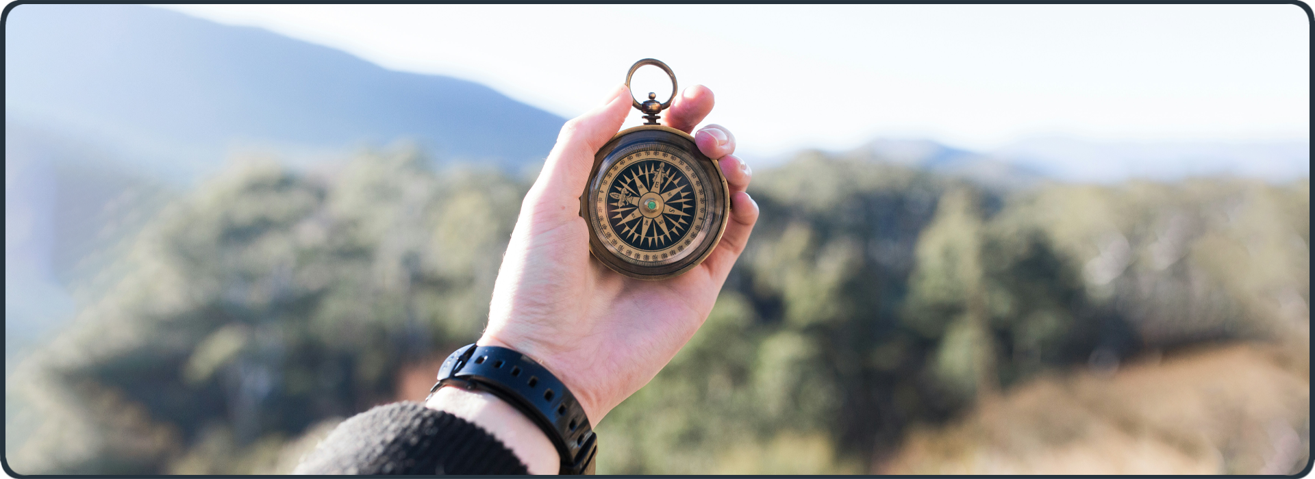 Kompass in der Hand vor weiter Landschaft – Symbol für Quereinstieg und neue berufliche Ausrichtung